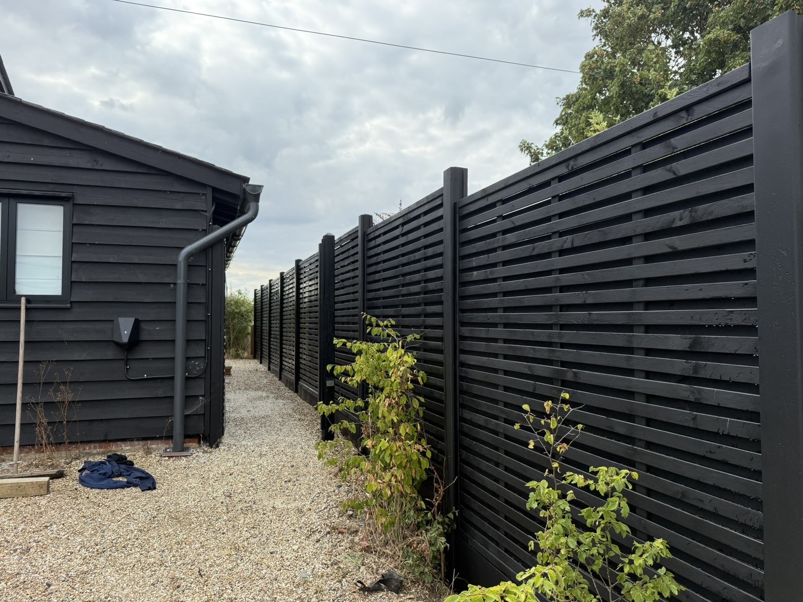 Modern black slatted fencing installation by DAGardenServices